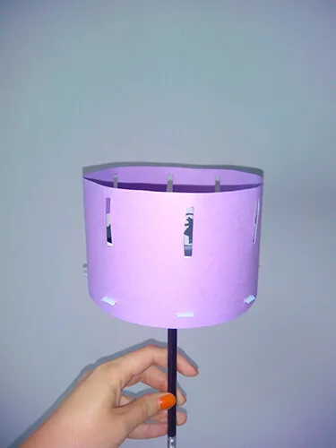 Mano sosteniendo un instrumento de percusión iluminado en tonos violeta durante una sesión de musicoterapia