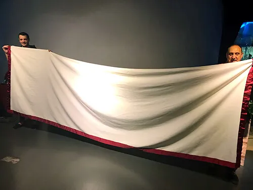 Tela blanca desplegada sobre el escenario en una escena de teatro