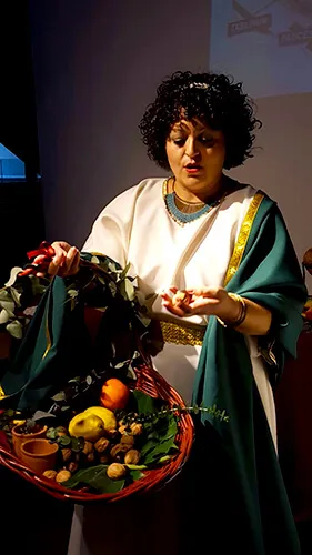 Mujer con túnica romana sosteniendo una cesta con frutas y hojas